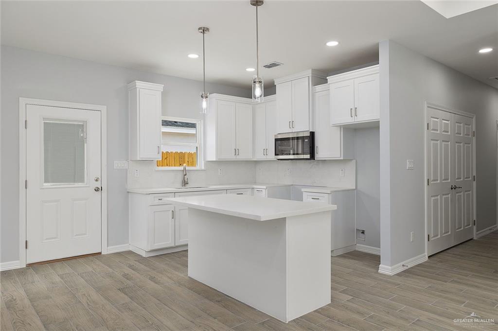 412 East Acacia Avenue, Unit 1 Alamo, TX 78516 - Photo 14 of 22 a kitchen with stainless steel appliances granite countertop a sink a stove a refrigerator and white cabinets