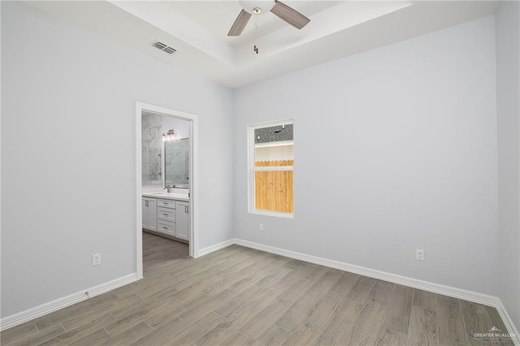 412 East Acacia Avenue, Unit 1 Alamo, TX 78516 - Photo 15 of 22 an empty room with a window and wooden floor
