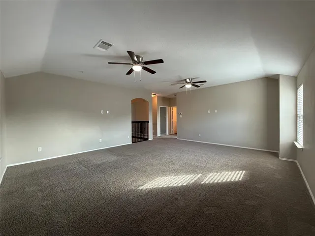 an empty room with a window and a fan