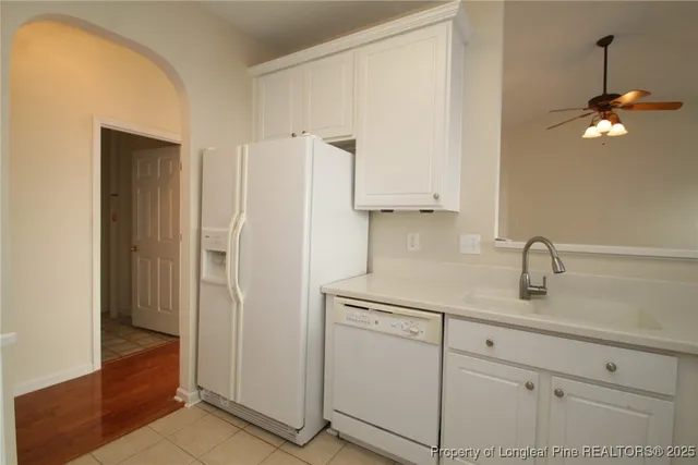 a kitchen with a refrigerator sink and cabinets