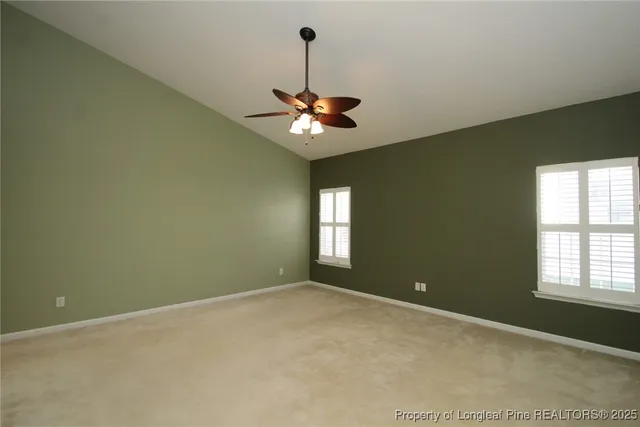 a view of an empty room with a chandelier fan