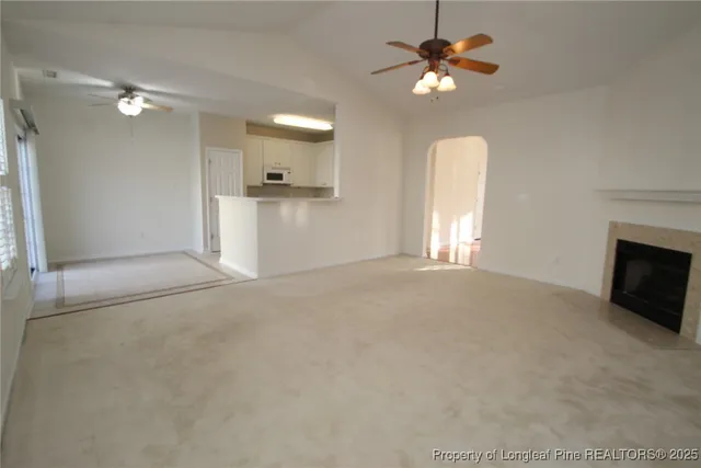 a view of an empty room with a fireplace and a window