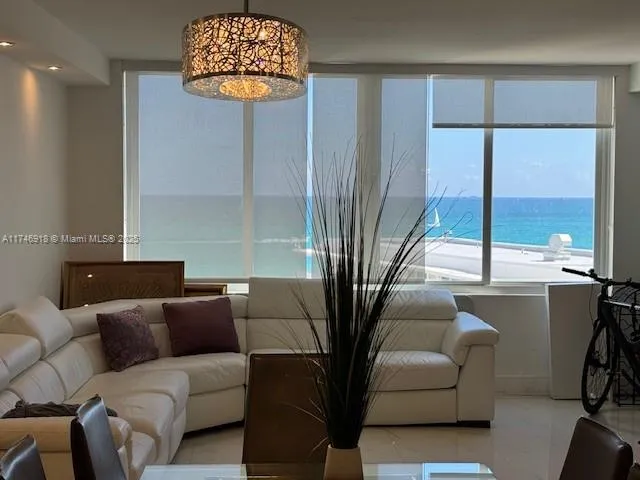 a living room with furniture a window and a chandelier
