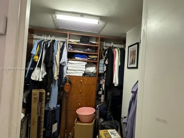 a view of walk in closet with clothes and shoes
