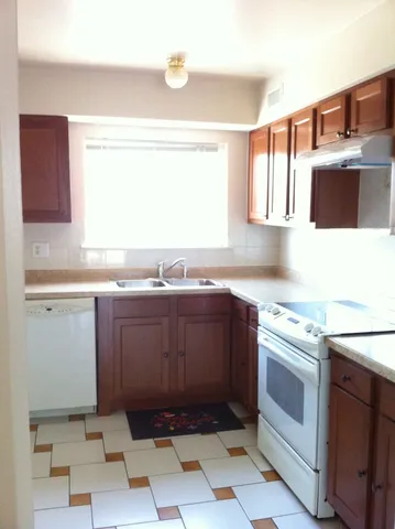 a kitchen with stainless steel appliances granite countertop a sink and a stove