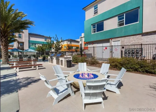 a view of a patio with a dining table and chairs with a fire pit