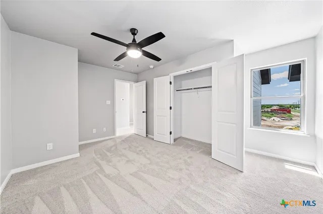 a view of a livingroom with a ceiling fan and window