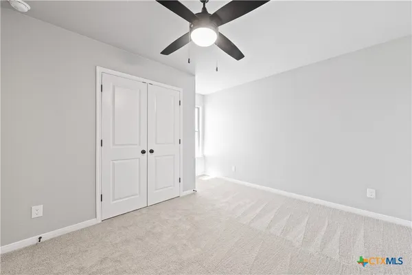 an empty room with a ceiling fan and a window