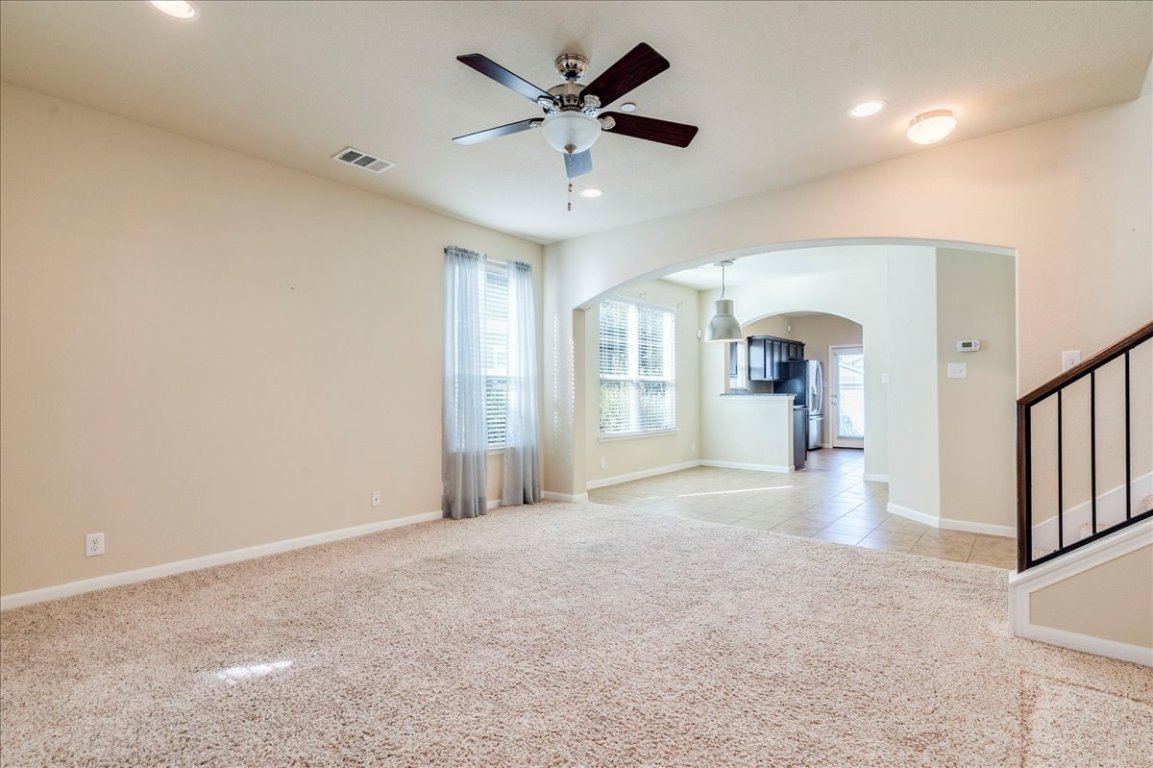 512 Lookout Tree Lane Round Rock, TX 78664 - Photo 4 of 29 Empty room with ceiling fan, light colored carpet, arched walkways, recessed lighting, and stairs