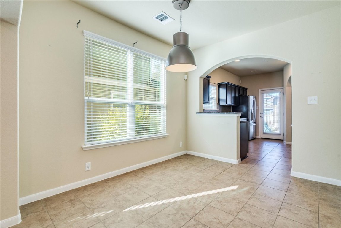 512 Lookout Tree Lane Round Rock, TX 78664 - Photo 8 of 29 Unfurnished dining area with arched walkways, healthy amount of natural light, and light tile patterned floors