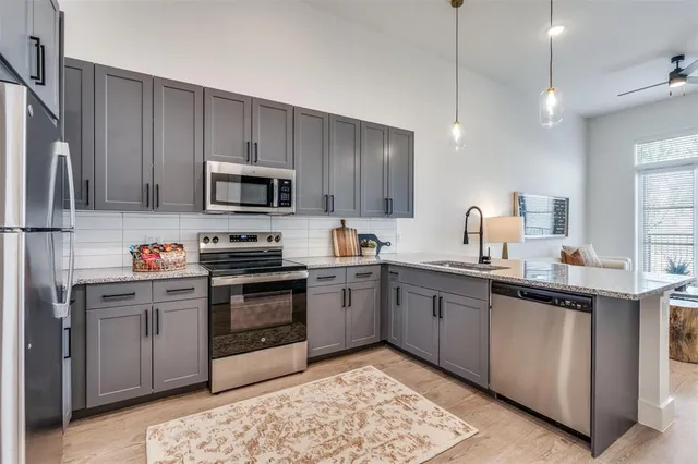 a kitchen with stainless steel appliances kitchen island granite countertop a stove a sink a refrigerator and chairs