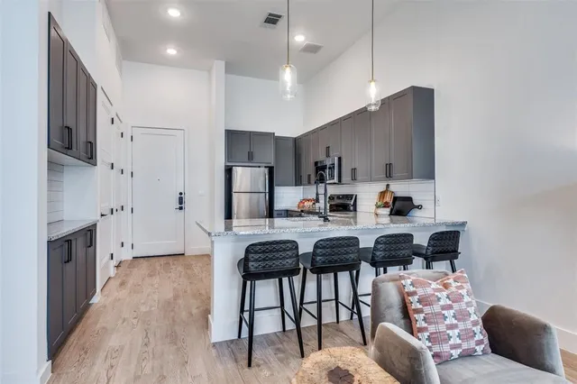 a kitchen with kitchen island a counter top space cabinets and stainless steel appliances