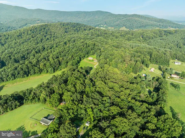 an aerial view of a house with a yard and trees