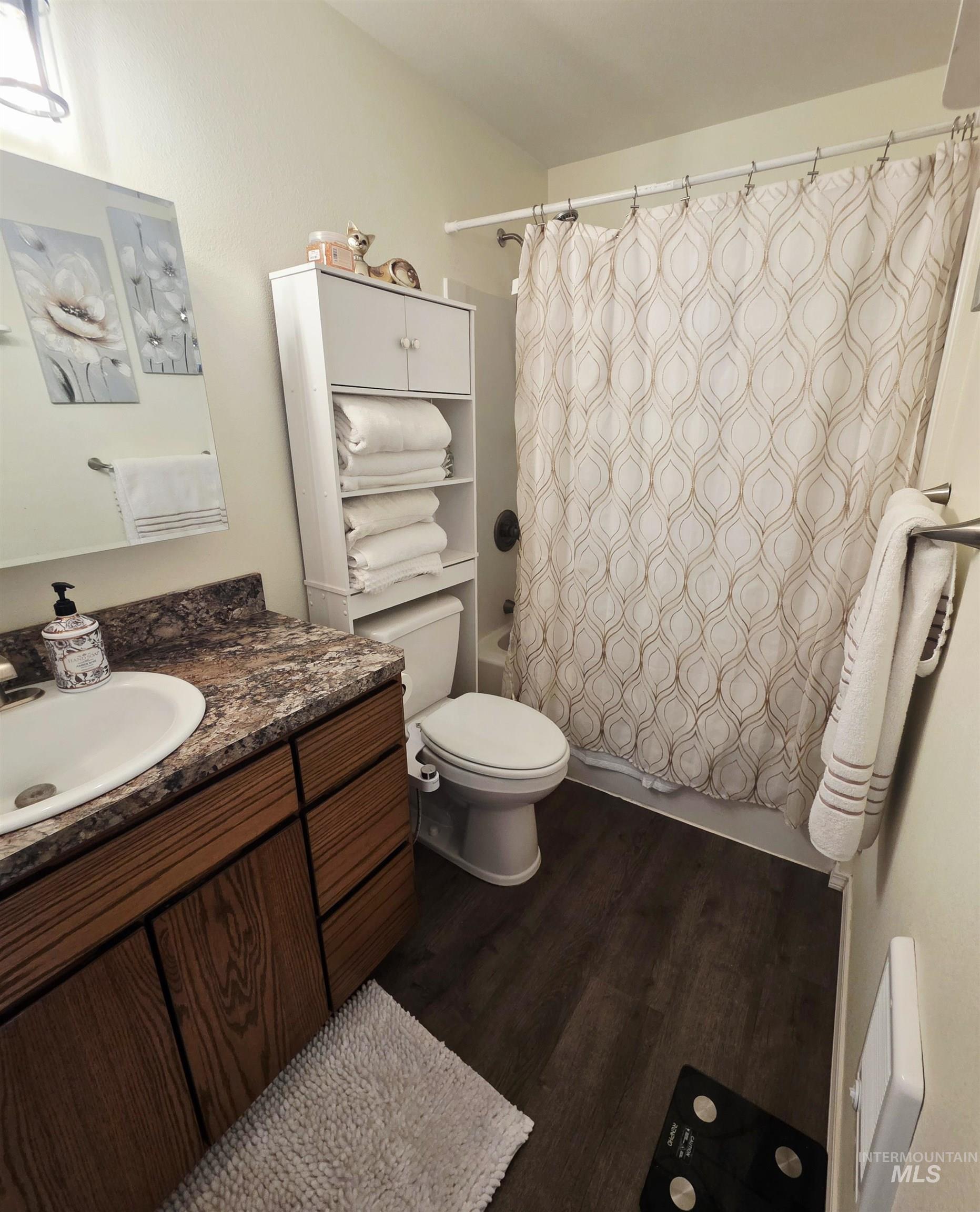 409 8th Street Clarkston, WA 99403 - Photo 6 of 23 Bathroom featuring a vanity with wood-finish cabinetry, a white basin sink, and a speckled countertop
