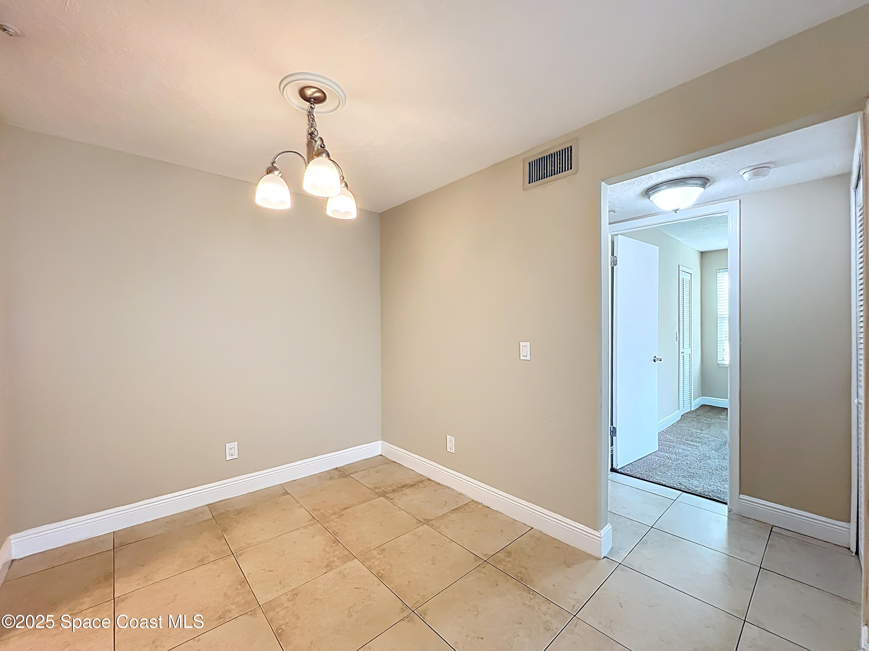 7667 North Wickham Road, Unit 410 Melbourne, FL 32940 - Photo 14 of 37 a view of a chandelier in big room and a bathroom