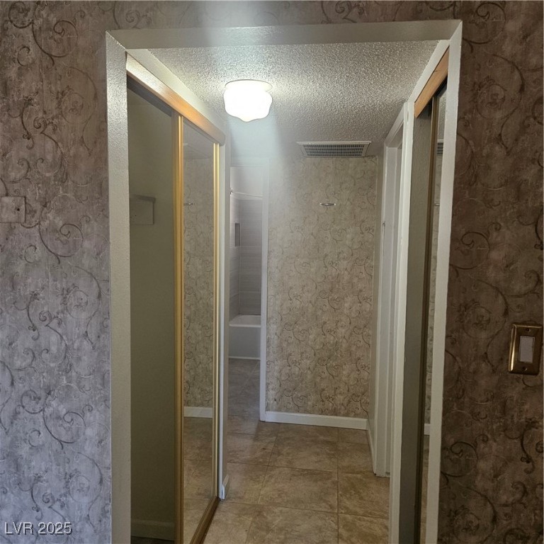 350 East Desert Inn Road, Unit C203 Las Vegas, NV 89109 - Photo 15 of 35 Hall with a textured ceiling, light tile patterned flooring, and wallpapered walls