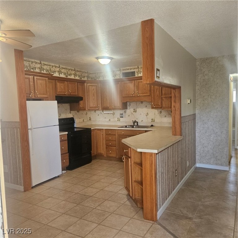 350 East Desert Inn Road, Unit C203 Las Vegas, NV 89109 - Photo 4 of 35 Kitchen with a wainscoted wall, wallpapered walls, light countertops, open shelves, and stove