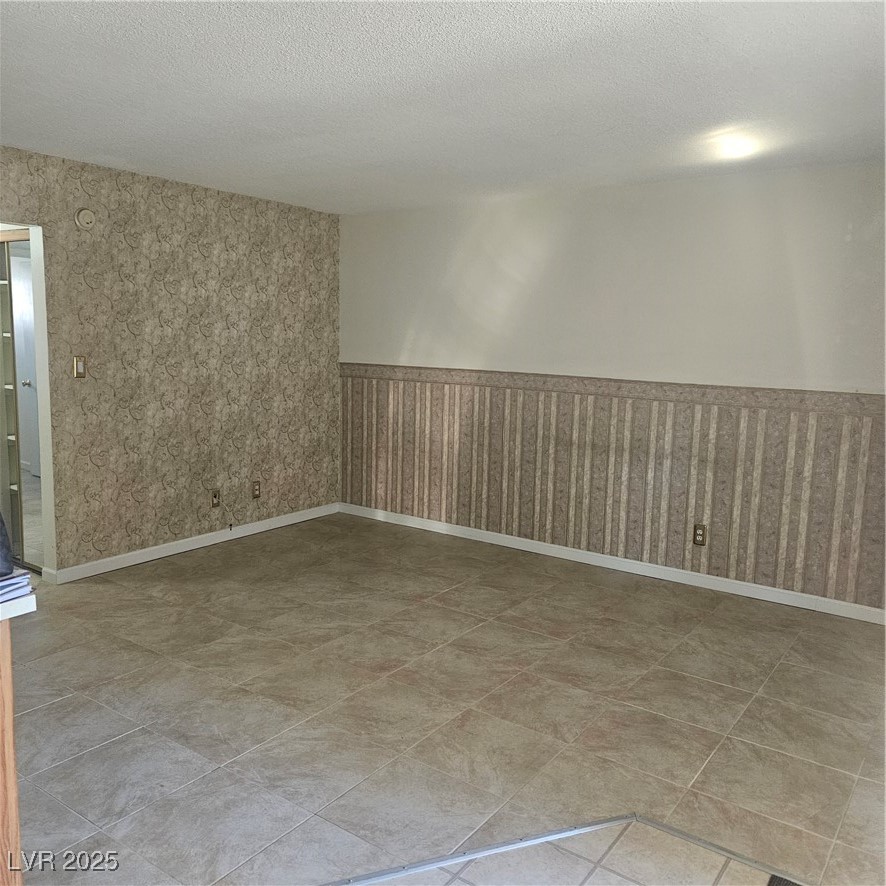 350 East Desert Inn Road, Unit C203 Las Vegas, NV 89109 - Photo 7 of 35 Spare room with wainscoting, a textured ceiling, and wallpapered walls