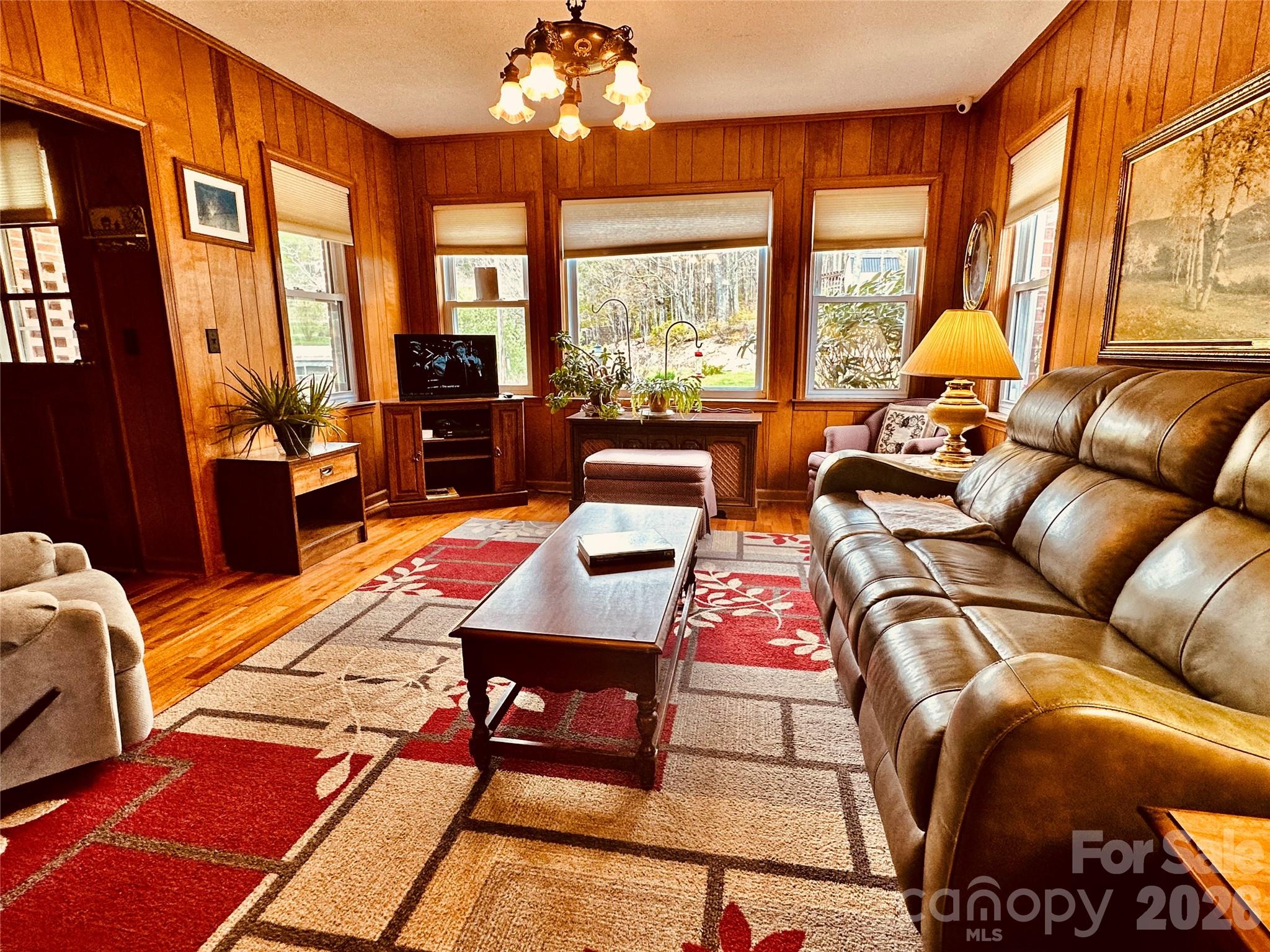 580 Russ Norris Heaton Road Elk Park, NC 28622 - Photo 11 of 42 a living room with furniture a chandelier and a floor to ceiling window
