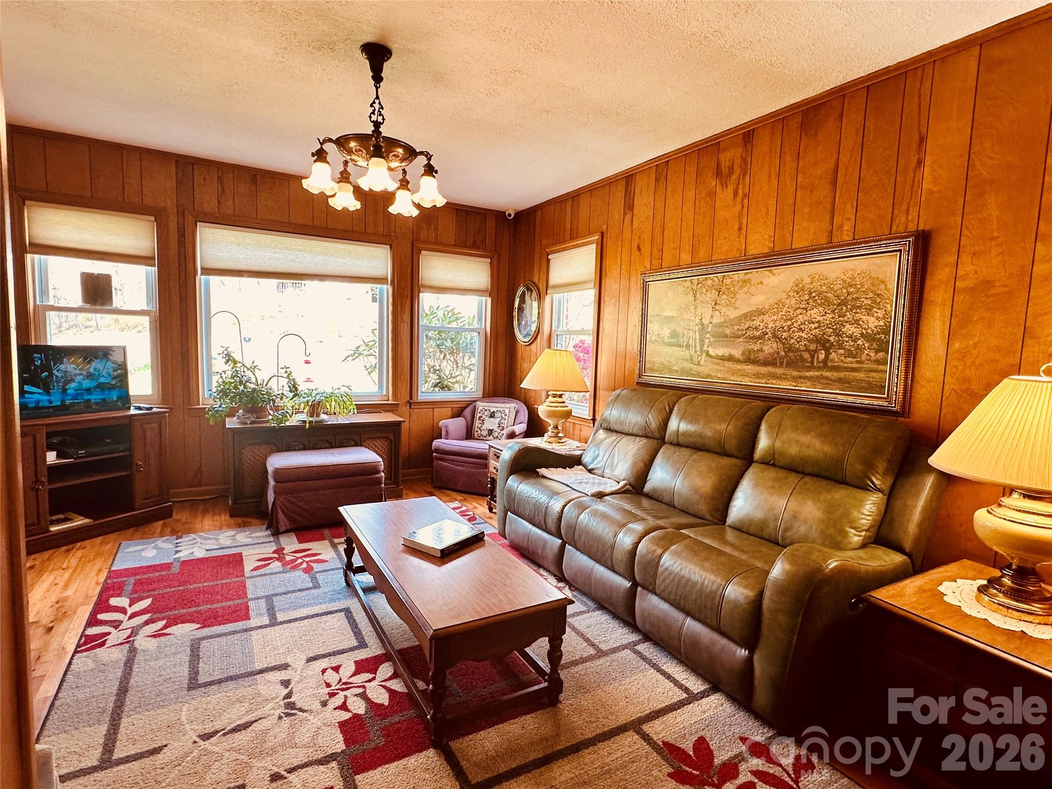 580 Russ Norris Heaton Road Elk Park, NC 28622 - Photo 12 of 42 a living room with furniture a chandelier and a floor to ceiling window