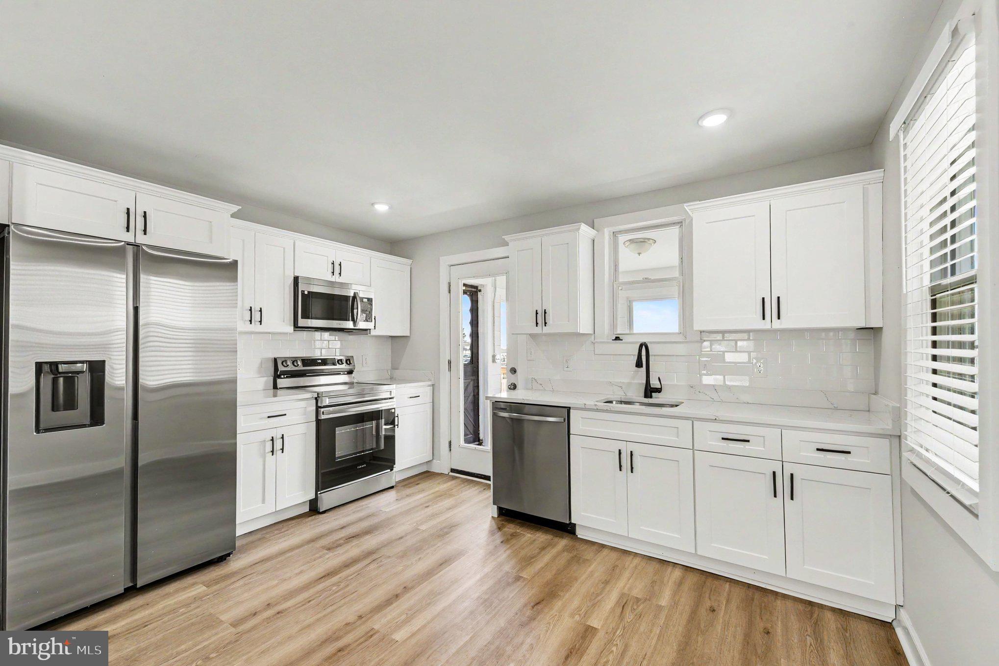 9135 Cuckold Point Road Sparrows Point, MD 21219 - Photo 9 of 44 a kitchen with a sink white cabinets and stainless steel appliances