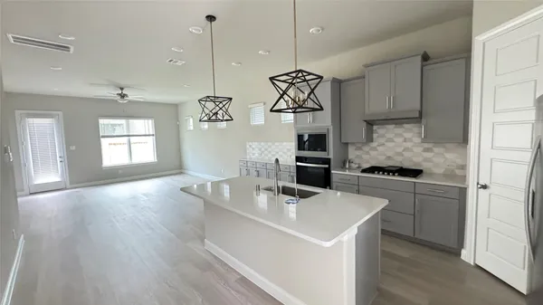 a kitchen with a sink a stove a refrigerator and chandelier