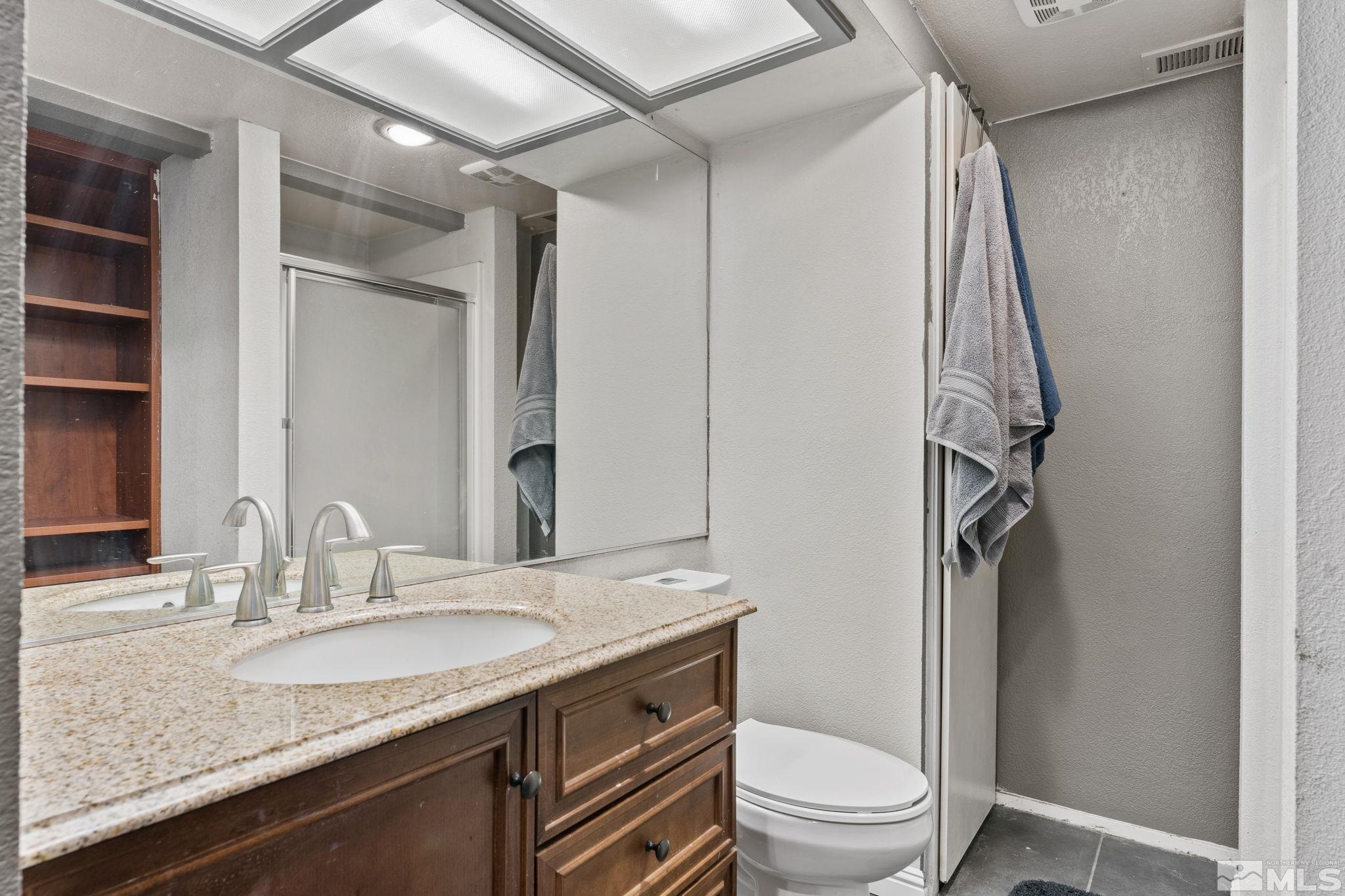 4185 Baker Lane Reno, NV 89509 - Photo 20 of 29 a bathroom with a granite countertop sink toilet and shower