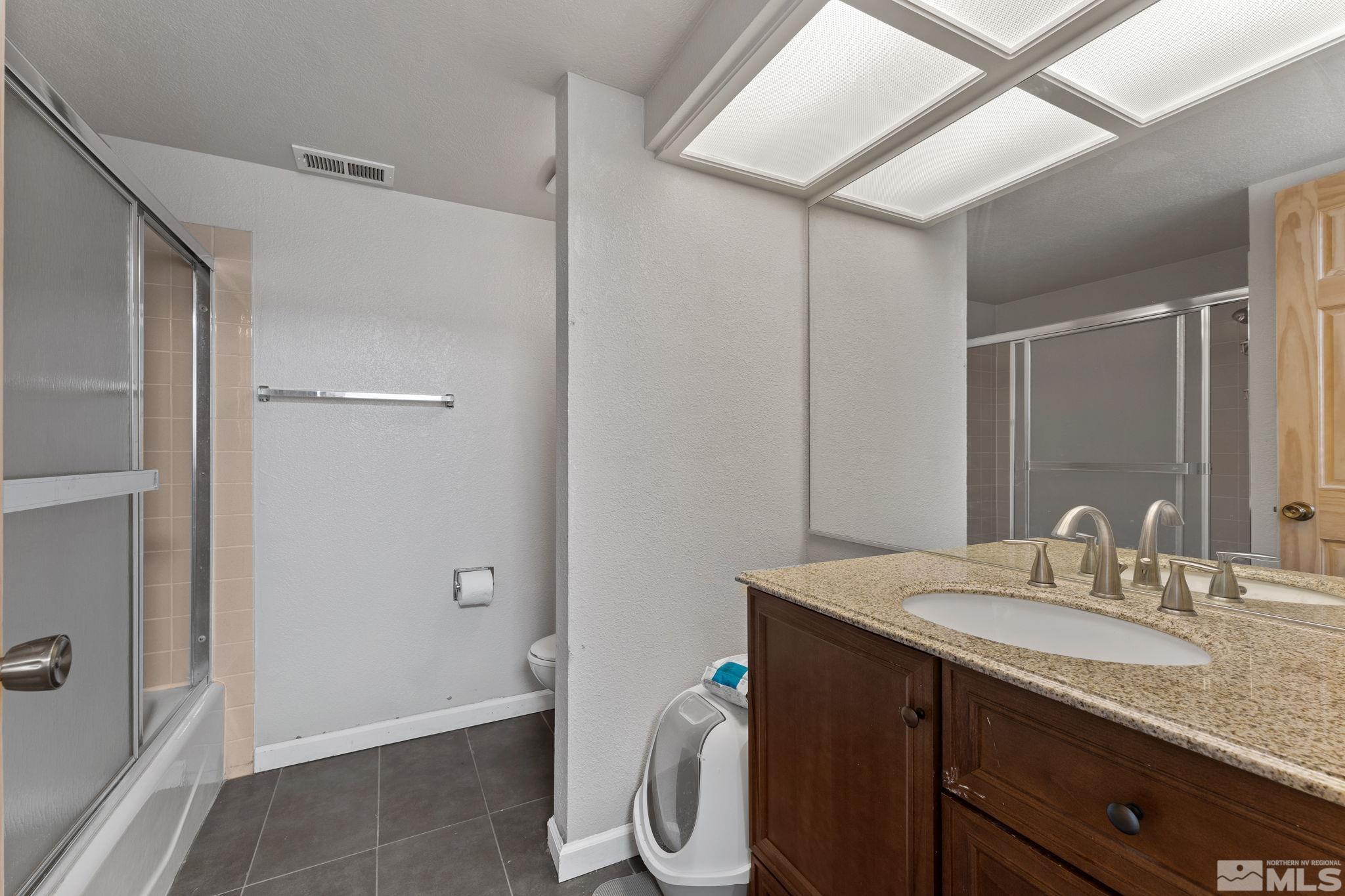 4185 Baker Lane Reno, NV 89509 - Photo 21 of 29 a bathroom with a granite countertop sink and a mirror