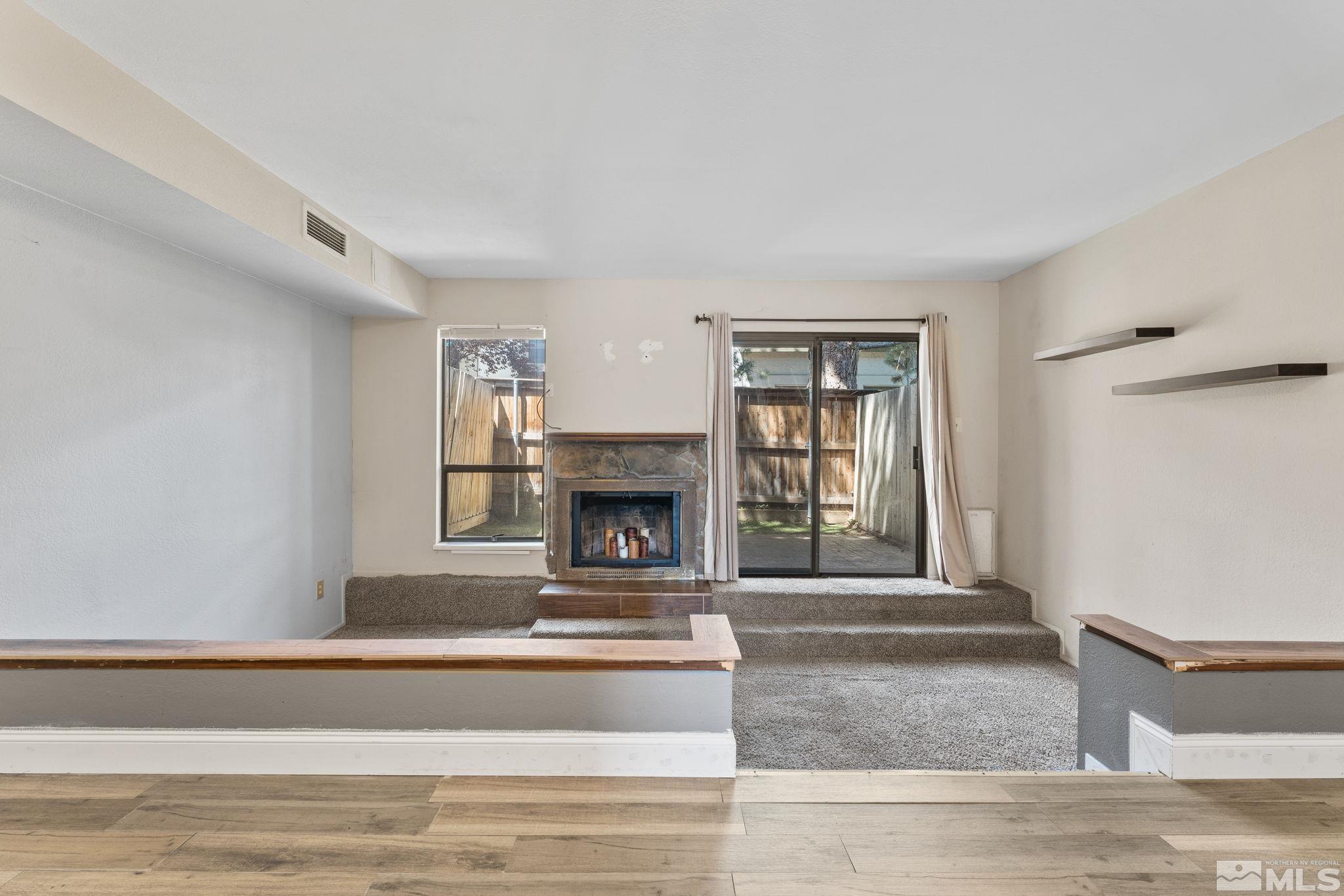 4185 Baker Lane Reno, NV 89509 - Photo 7 of 29 a living room with a fireplace and a floor to ceiling window