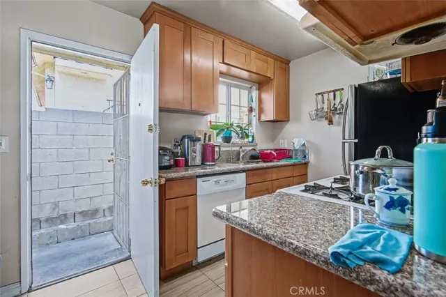 a kitchen with granite countertop a sink stove and cabinets