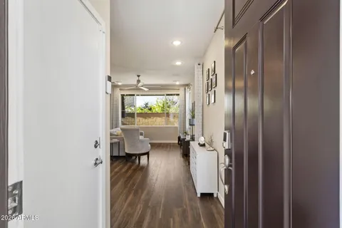 a view of a hallway with wooden floor and furniture