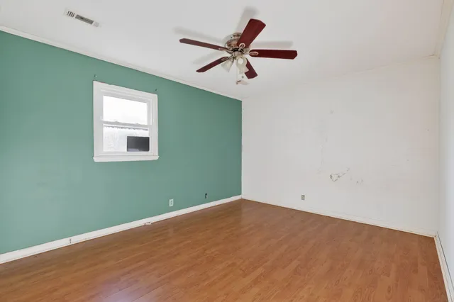 an empty room with a window and a fan