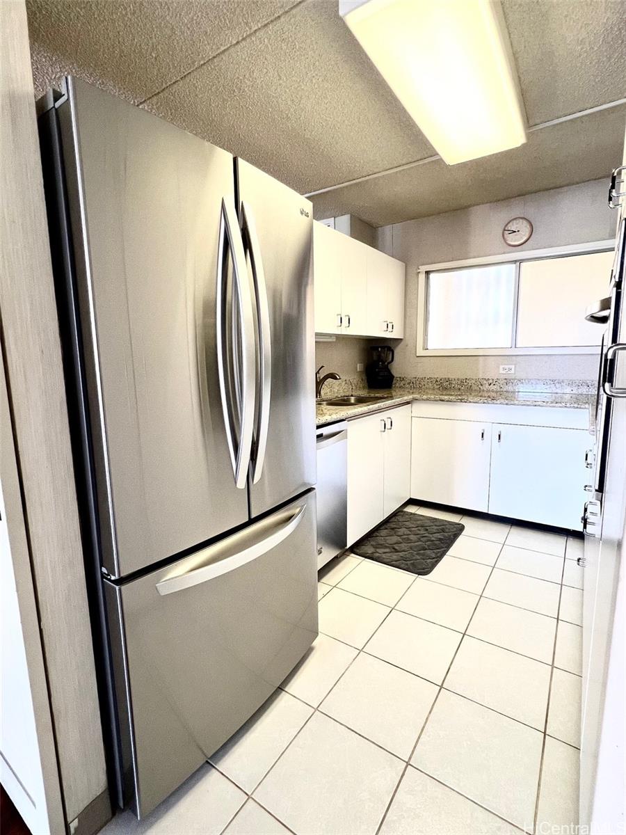 469 Ena Road, Unit 2010 Honolulu, HI 96815 - Photo 11 of 25 a kitchen with a refrigerator a sink and cabinets
