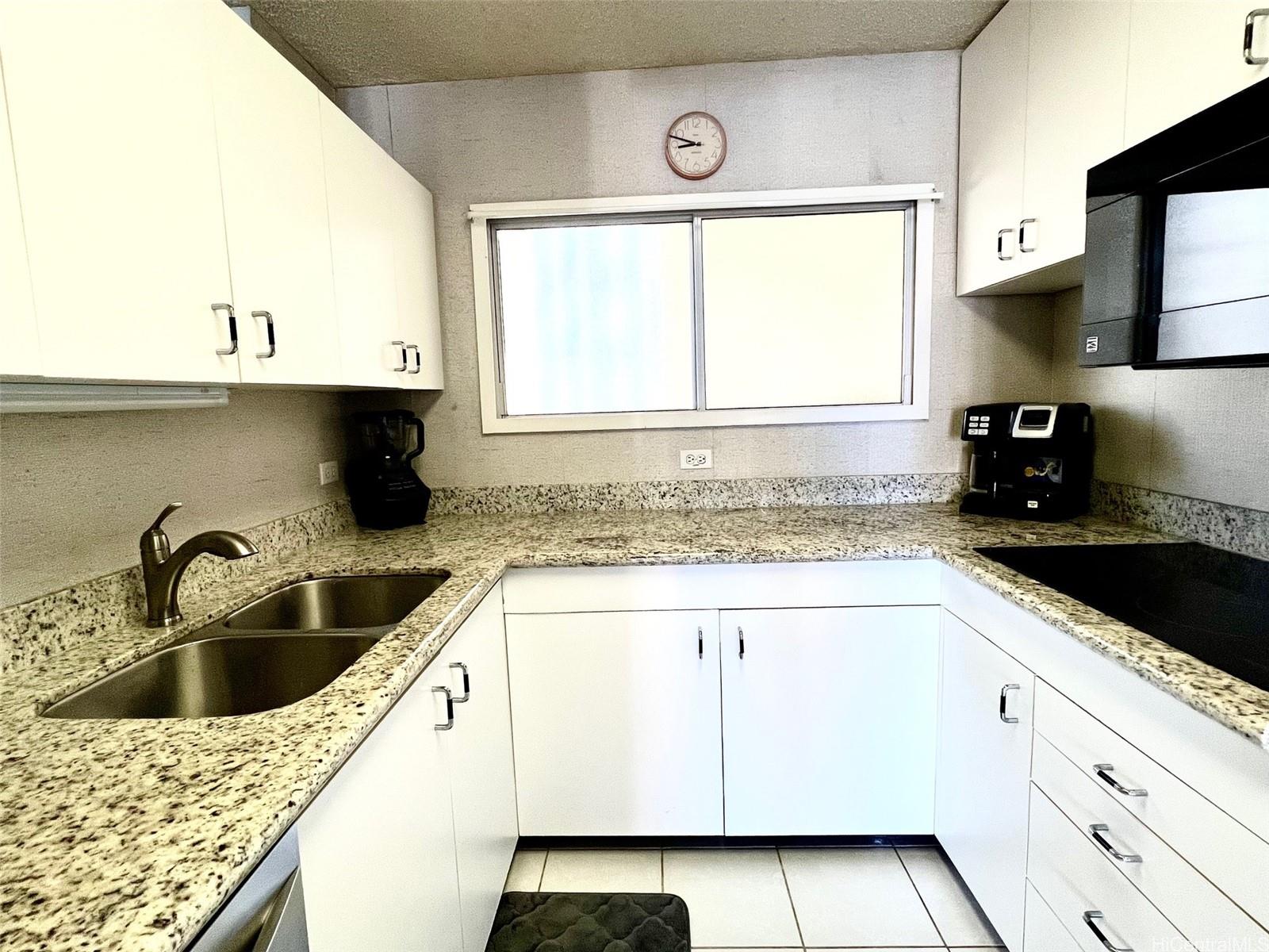 469 Ena Road, Unit 2010 Honolulu, HI 96815 - Photo 12 of 25 a kitchen with granite countertop a sink and a stove