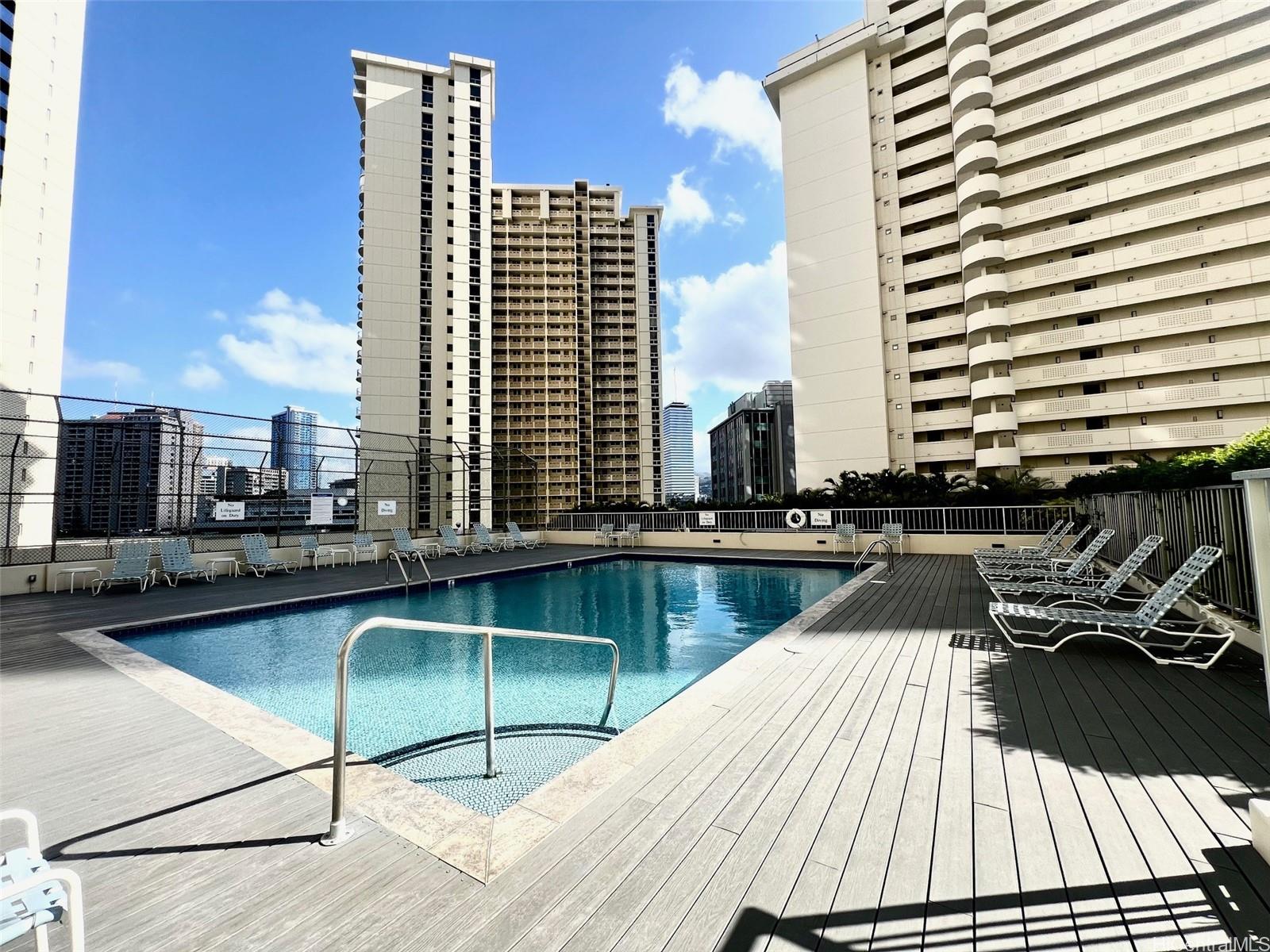 469 Ena Road, Unit 2010 Honolulu, HI 96815 - Photo 18 of 25 a view of a patio with couches chairs and wooden floor