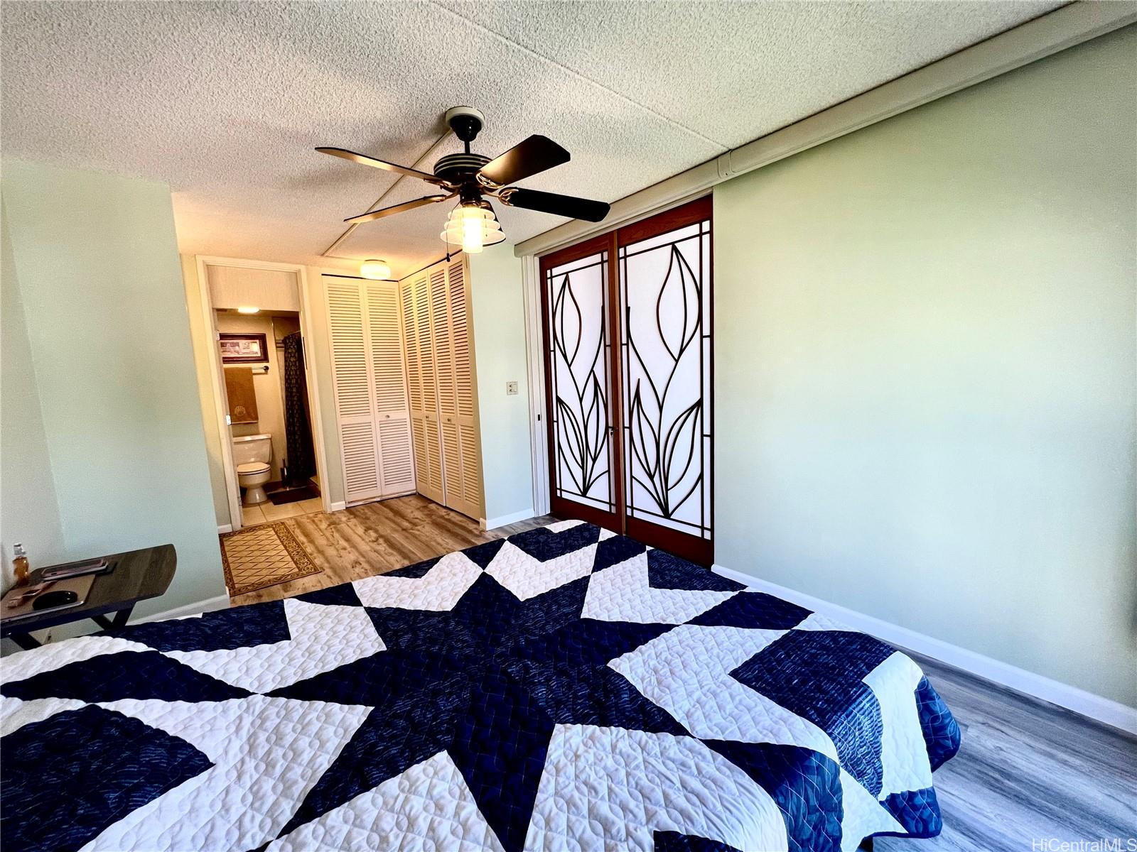 469 Ena Road, Unit 2010 Honolulu, HI 96815 - Photo 7 of 25 a bedroom with a bed and a chandelier