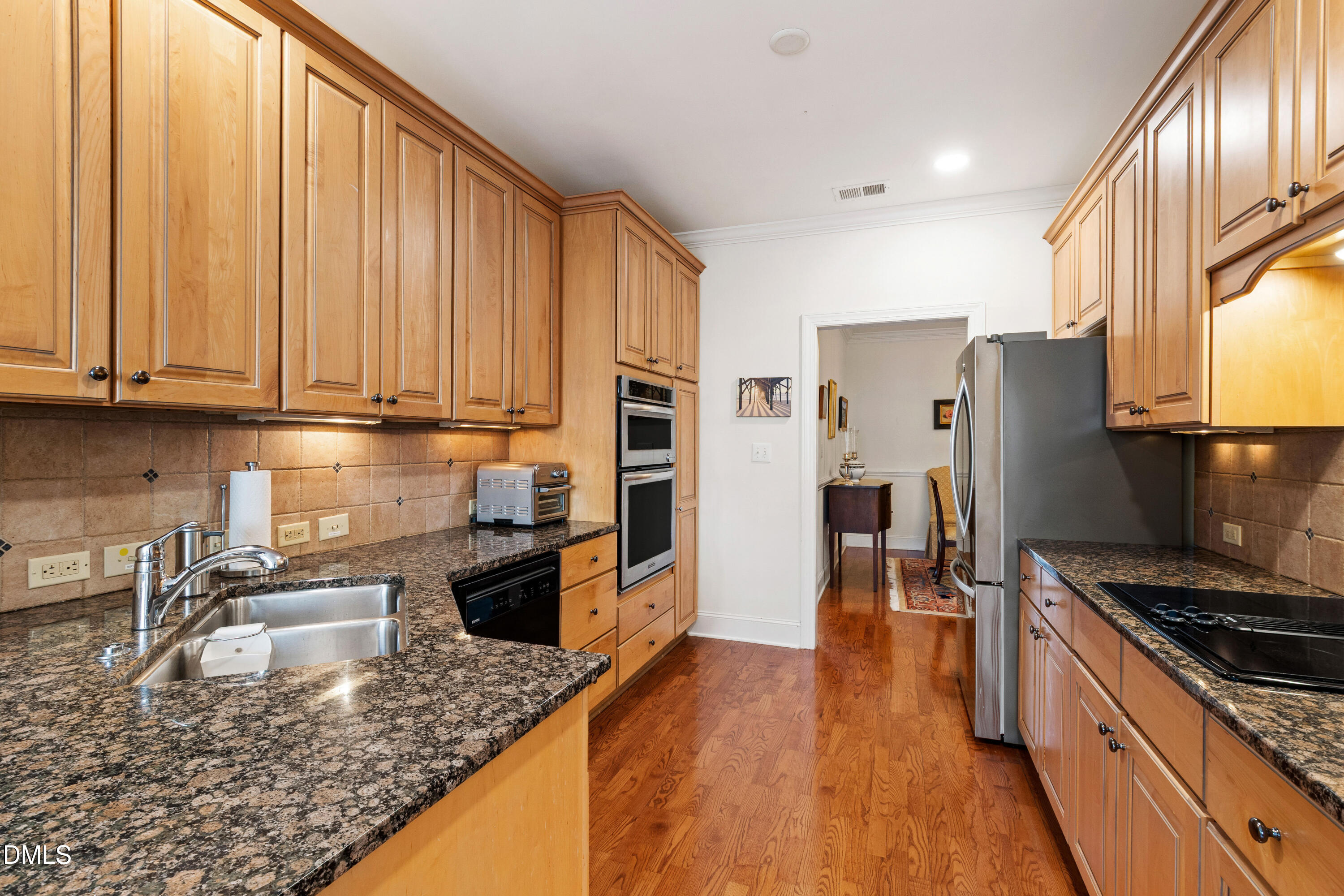3700 Baron Cooper Pass, Unit 105 Raleigh, NC 27612 - Photo 5 of 49 a kitchen with stainless steel appliances granite countertop a stove top oven a sink and a refrigerator