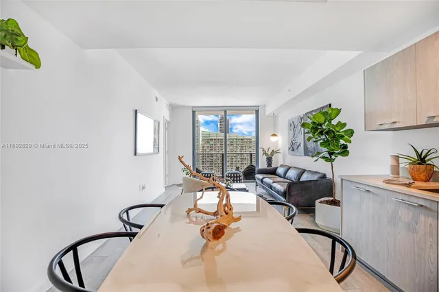 a kitchen with stainless steel appliances a table and chairs in it