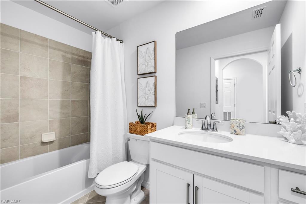 43989 Boardwalk Loop, Unit 2032 Punta Gorda, FL 33982 - Photo 14 of 14 a bathroom with a bathtub shower sink vanity mirror and toilet