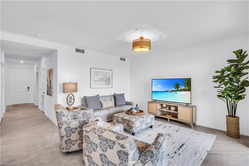 43989 Boardwalk Loop, Unit 2032 Punta Gorda, FL 33982 - Photo 5 of 14 a living room with furniture a flat screen tv and a potted plant