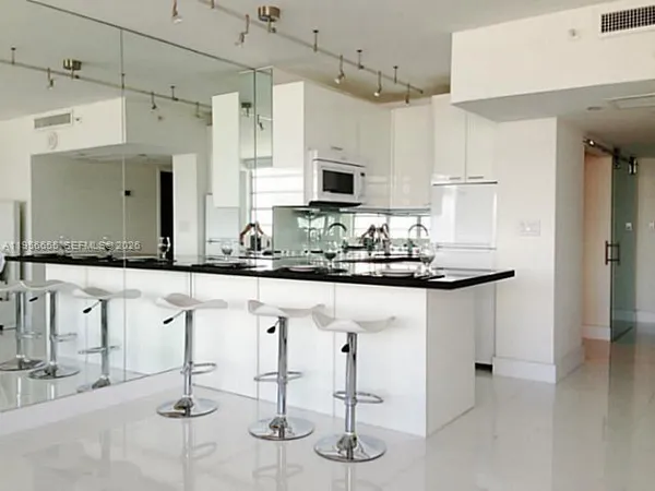 a kitchen with stainless steel appliances kitchen island granite countertop a stove a sink and a refrigerator