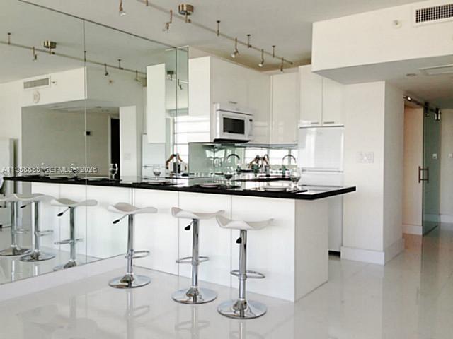 100 Lincoln Road, Unit 1112 Miami Beach, FL 33139 - Photo 2 of 48 a kitchen with stainless steel appliances kitchen island granite countertop a stove a sink and a refrigerator