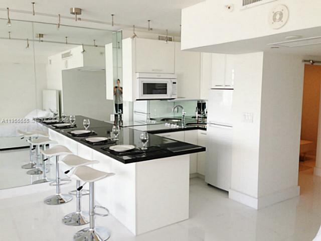 100 Lincoln Road, Unit 1112 Miami Beach, FL 33139 - Photo 3 of 48 a kitchen with stainless steel appliances granite countertop a sink and cabinets