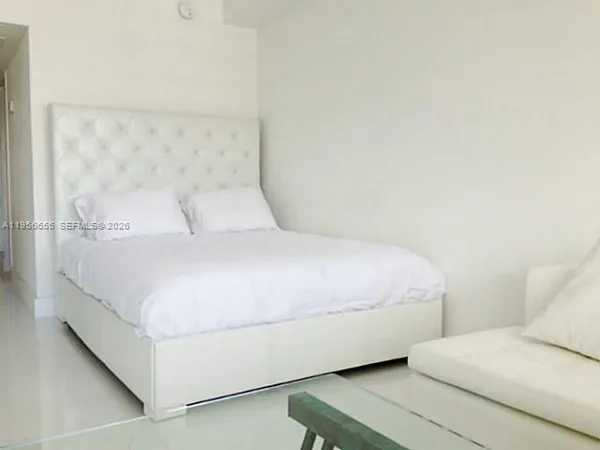 a bedroom with a bed and a white wall