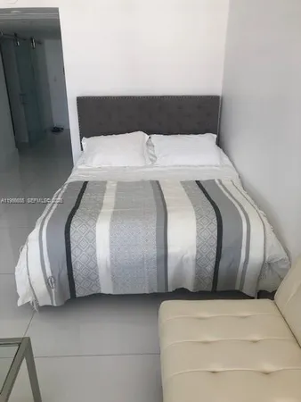 a bedroom with a bed and a television