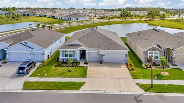an aerial view of a house with a swimming pool yard and ocean view