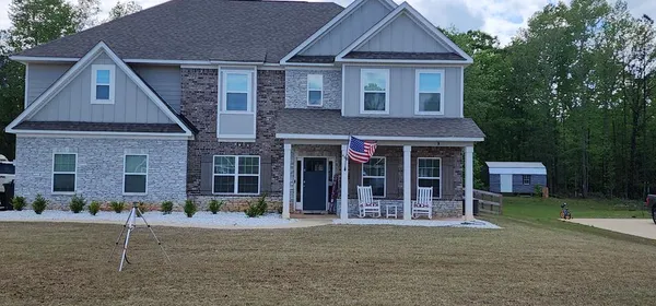 a front view of a house with a garden and plants