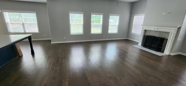 an empty room with wooden floor and fireplace