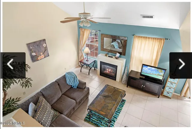 a living room with furniture a fireplace and a flat screen tv