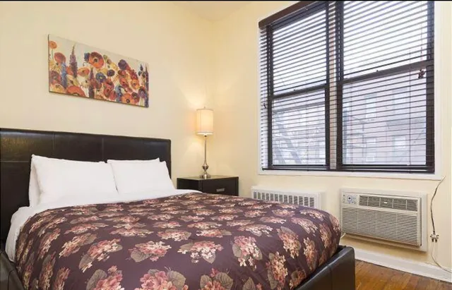 a bedroom with a bed and a painting on the wall